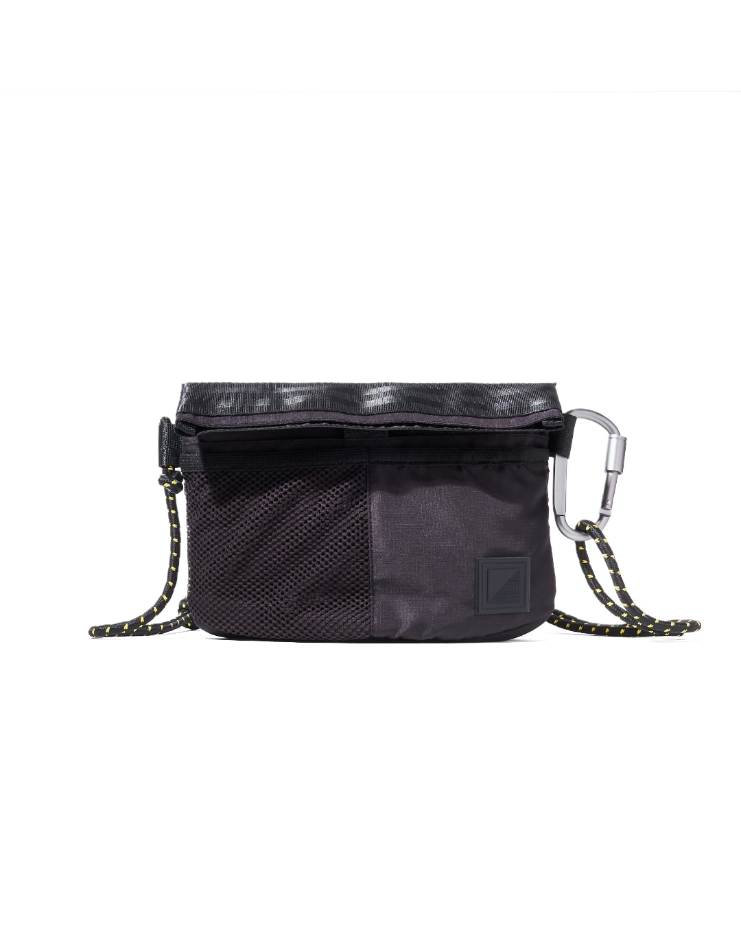 Close-up front view of the black SYMA Chain highlighting its quick-access half-mesh pocket, subtle logo patch, and side-attached silver carabiner. Compact sacoche bag.