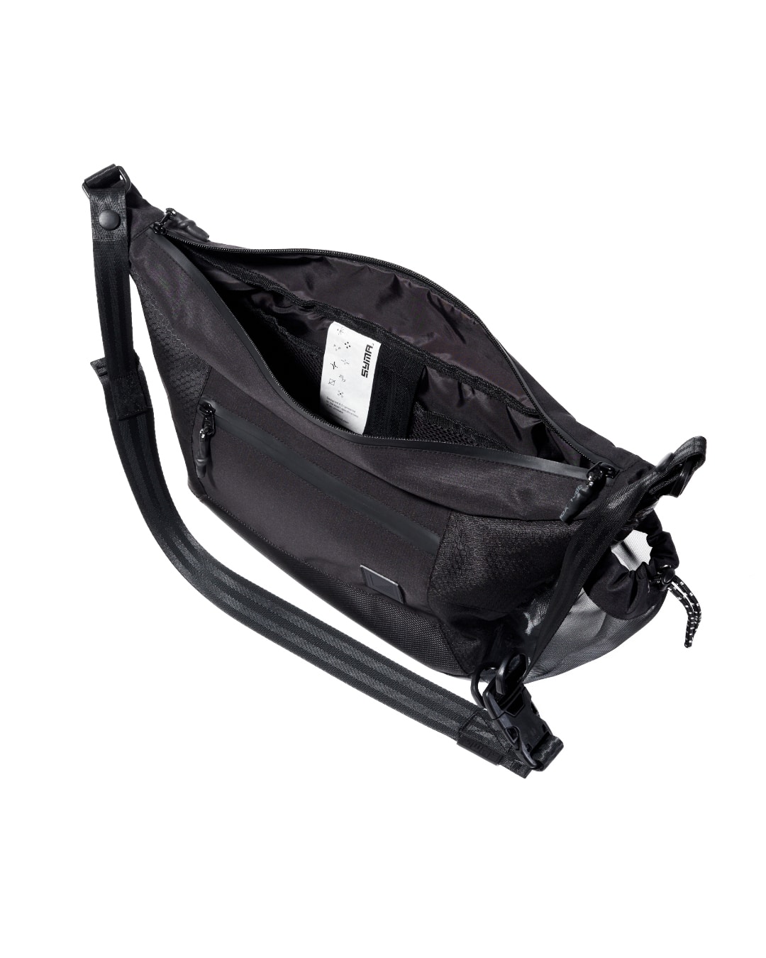 High-angle top view of the open black SYMA Drone highlighting its spacious main compartment, internal organization pockets, and signature woven label. Urban sling bag.