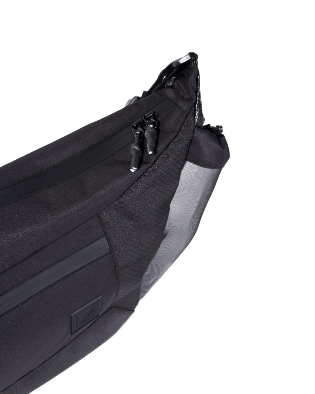 Close-up angled view of the black SYMA Drone highlighting its textured ripstop fabric, double paracord zipper pulls, and side mesh pocket. Urban sling bag.
