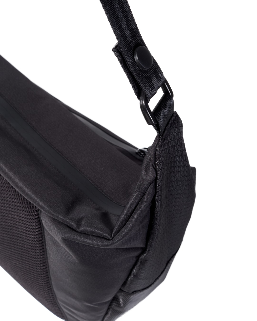 Close-up angled view of the black SYMA Drone highlighting its robust strap attachment hardware, main zipper, and mesh back panel integration. Urban sling bag.