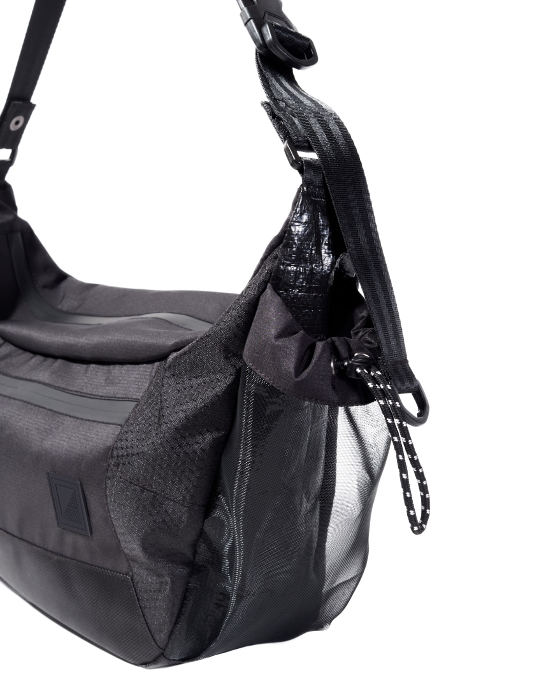 Close-up side angled view of the black SYMA Drone highlighting its expandable side mesh pocket and adjustable paracord drawstring closure. Urban sling bag.