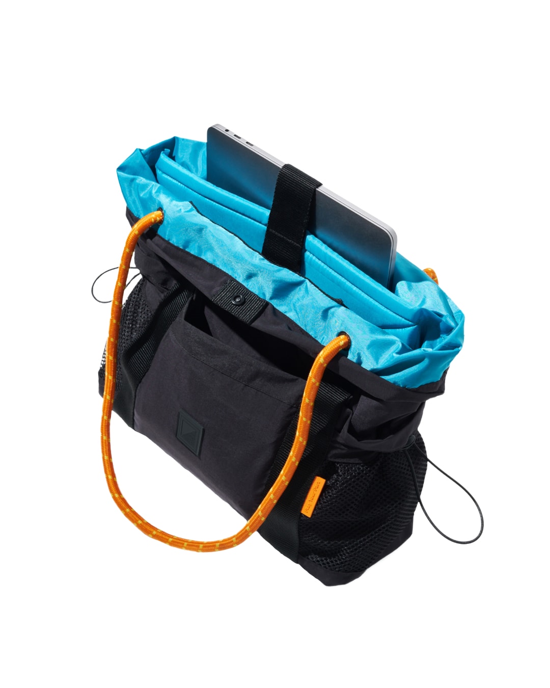 Angled open view of the black SYMA Noble minimalist everyday tote bag, revealing the bright blue nylon interior lining, orange paracord straps, and a dedicated sleeve securely holding a 13-inch laptop