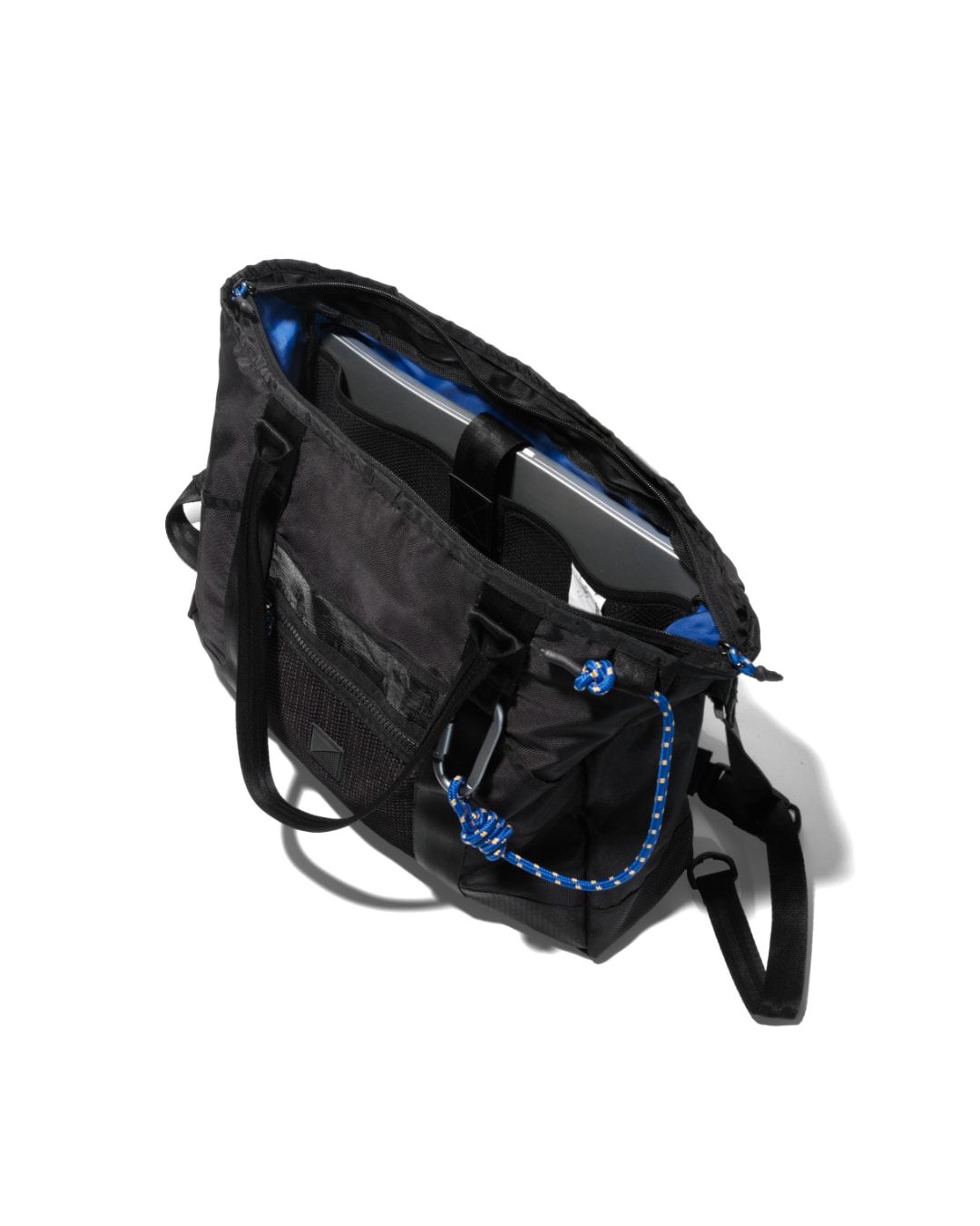 Interior open view of black SYMA Miles Tote Bag showing laptop inside dedicated sleeve with contrast blue lining. Versatile work tote bag