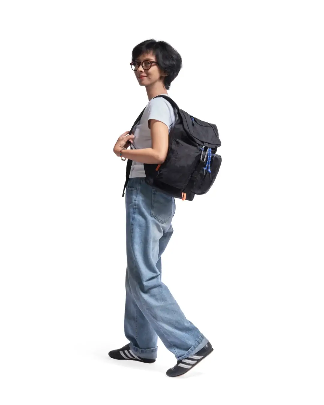 Woman in casual creative outfit walking with the black SYMA Ribbons Backpack over her shoulder. A 12L compact daily backpack.