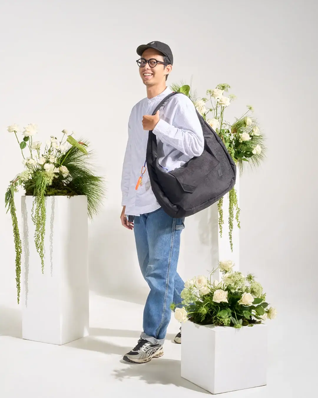 Man wearing SYMA Fable Sling Bag Black on shoulder. Oversized urban commuter messenger bag