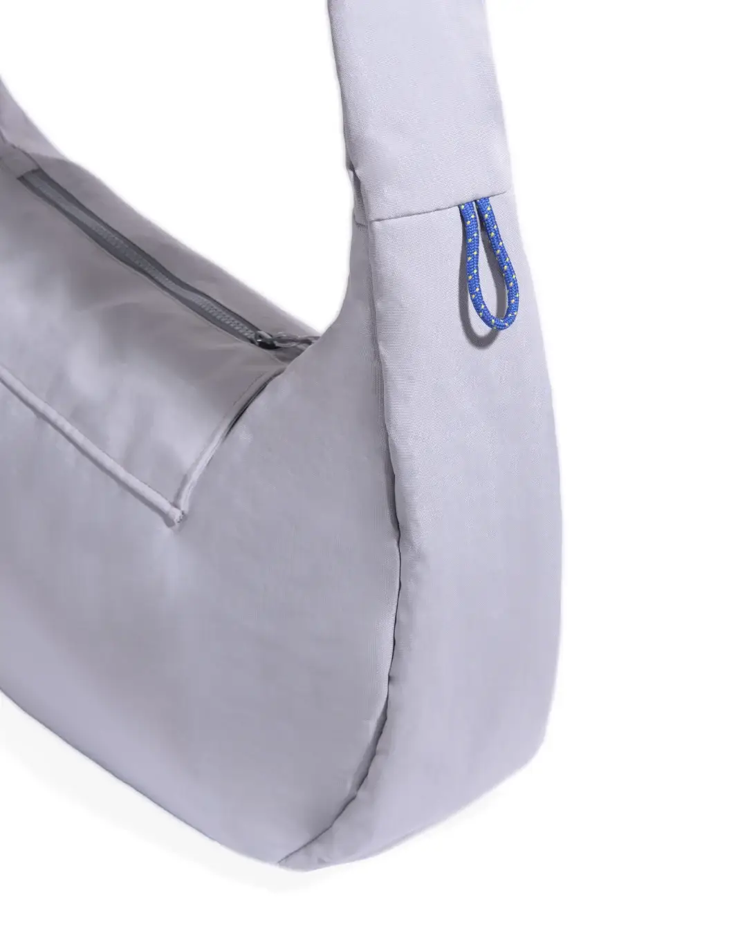 Close-up view of SYMA Fable Sling Bag Light Grey highlighting side paracord charm loop and zipper. Minimalist tech messenger