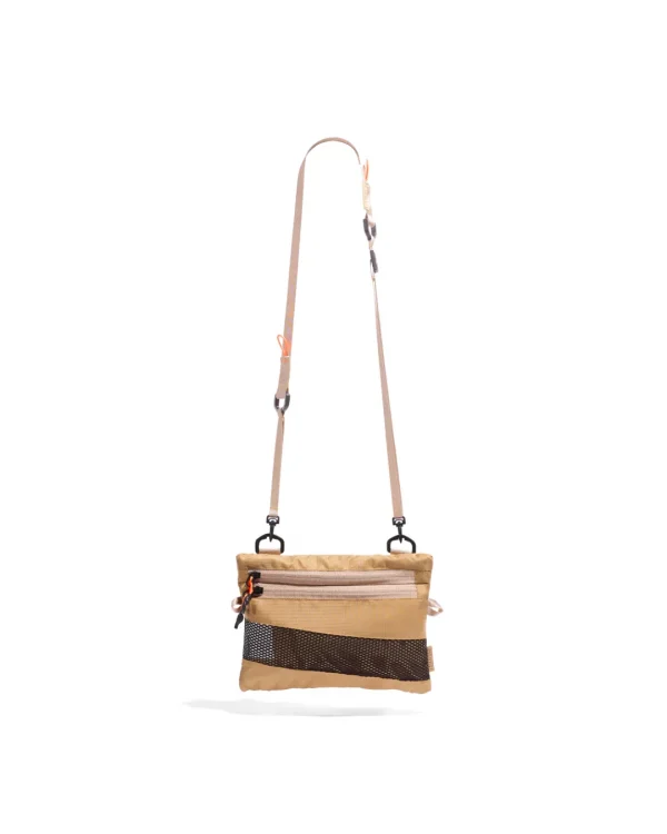 Front suspended view of the SYMA Mantra khaki sacoche bag, highlighting its durable polyester ripstop exterior, dual front zipper pockets with orange pullers, bottom mesh detailing, and adjustable removable strap